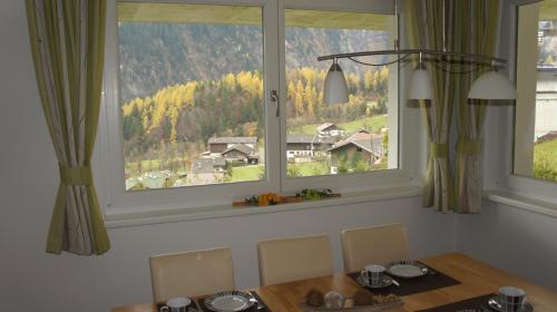 a dining room with a table and two large windows at Bergblick in Finkenberg