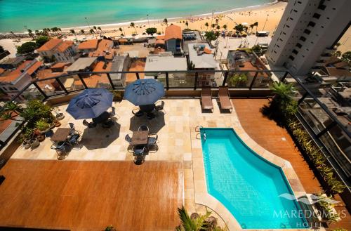 una vista aérea de una piscina con sombrillas y una playa en Maredomus Hotel, en Fortaleza