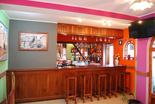 a bar with wooden bar stools in a room at Antsirabe Hotel in Antsirabe
