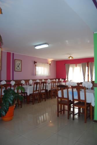 a dining room with tables and chairs and pink walls at Antsirabe Hotel in Antsirabe