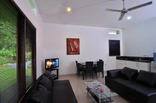 a living room with a black couch and a table at Dream Estate Resort in Senggigi 