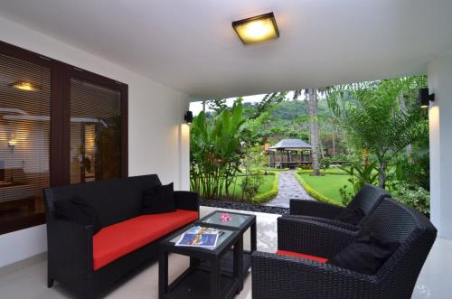 a living room with a couch and chairs and a table at Dream Estate Resort in Senggigi 