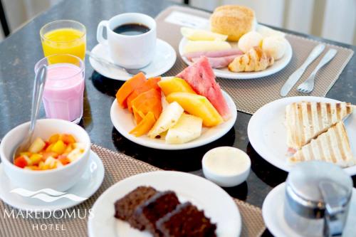 uma mesa com pratos de comida e uma xícara de café em Maredomus Hotel em Fortaleza