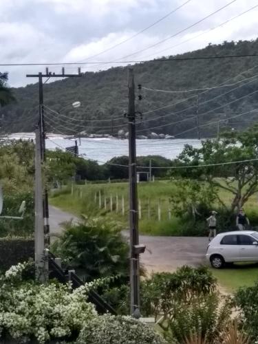 a car parked next to a road with a body of water at Solar Lisboa 100 m da Praia com vista para mar in Balneário Camboriú