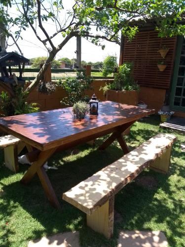 a wooden picnic table and benches in a yard at Solar Lisboa 100 m da Praia com vista para mar in Balneário Camboriú