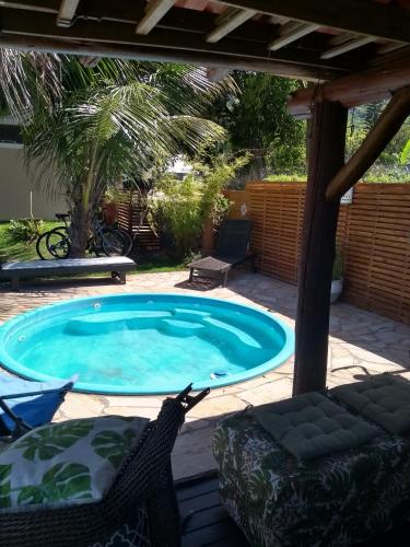 a swimming pool in a yard with two chairs at Solar Lisboa 100 m da Praia com vista para mar in Balneário Camboriú