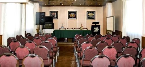 a room full of chairs with a table and a podium at Americana Hotel in Cochabamba