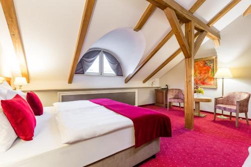 ein Schlafzimmer mit einem großen Bett im Dachgeschoss in der Unterkunft Myo Hotel Caruso in Prag