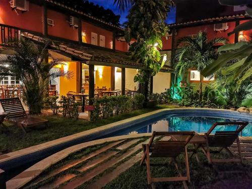 a house with a swimming pool in the yard at Pousada Tatuapara in Praia do Forte