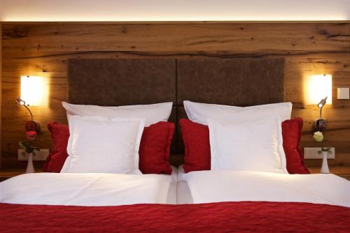 a bedroom with a bed with red and white pillows at Park Hotel Laim in Munich