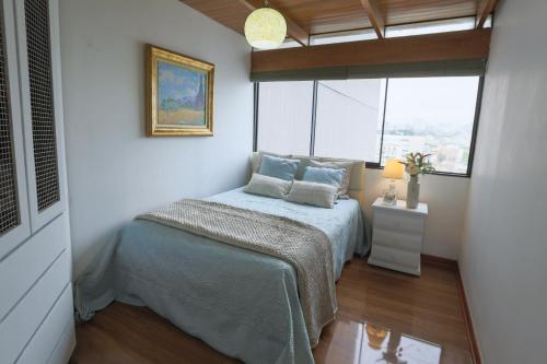 a small bedroom with a bed and a window at Oceanfront Penthouse in Miraflores in Lima