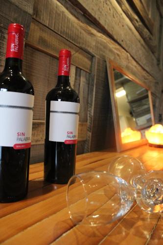 two bottles of wine sitting on a wooden table at Fitz Roy Hostería de Montaña - El Chaltén in El Chalten