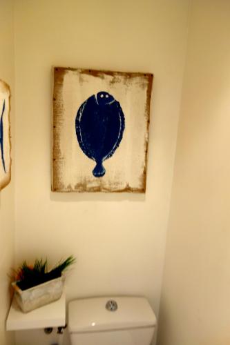 une peinture accrochée au-dessus des toilettes dans la salle de bains dans l'établissement Le Petit Chatelet appartement 3 au coeur de Paris, à Paris