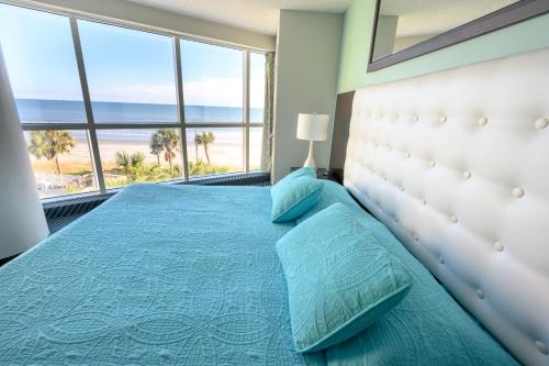 a bedroom with a bed with a view of the beach at New Ocean Front Corner Unit in Myrtle Beach