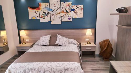 een slaapkamer met een bed met 2 nachtkastjes en 2 lampen bij B&B La Stazione in Diamante