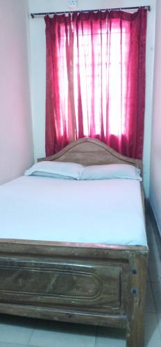 a bed in a room with a red window at Hotel As Shams International in Dhaka