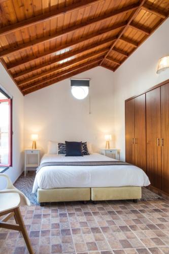 a bedroom with a large bed and wooden ceilings at Quinta do Torcaz in Horta