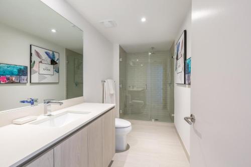 a bathroom with a sink and a toilet and a shower at Ocean Breeze Retreat - Pool Gym Access Views in Hallandale Beach