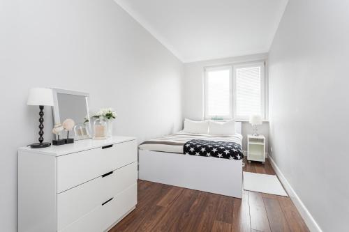 biała sypialnia z łóżkiem i komodą w obiekcie Apartament Forest - Parking - Praia Apartments Sopot Aquapark w mieście Sopot