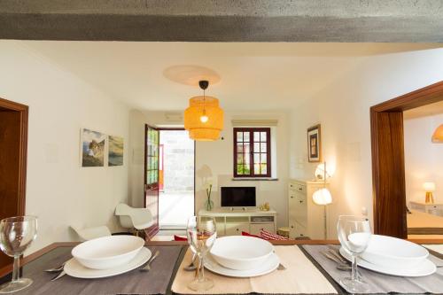 a dining room with a table with plates and wine glasses at Quinta do Torcaz in Horta