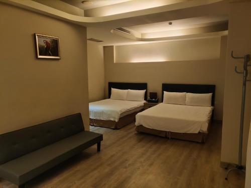 a hotel room with two beds and a couch at 君洋飯店Co-Living Hotel 龍潭科學園區 楊梅湖口 月租旅居共生宅 in Yangmei