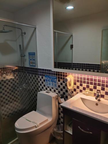 een badkamer met een toilet en een wastafel bij Empire Pacific Castle in Yangmei