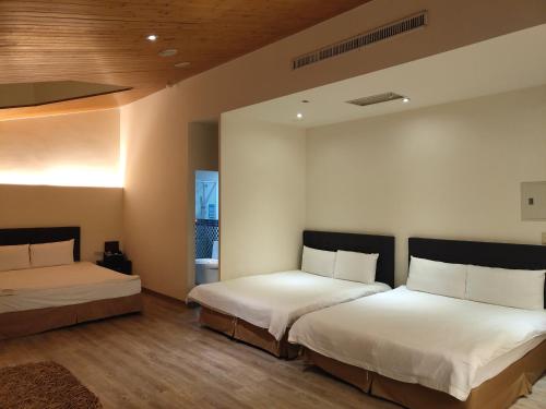 een slaapkamer met 2 bedden en witte lakens bij Empire Pacific Castle in Yangmei