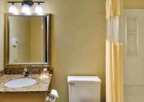 a bathroom with a sink and a toilet and a mirror at Windsor Hotel in East Windsor