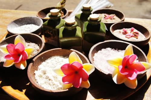 a group of bowls of rice and flowers on a table at Samba Villas Beachfront View in Gili Trawangan