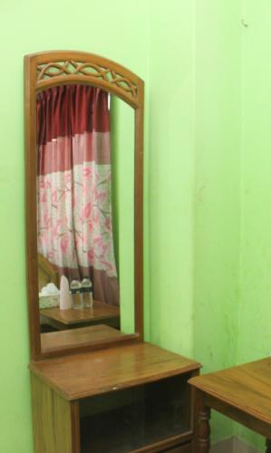 a mirror on a wooden table in a room at Hotel As Shams International in Dhaka