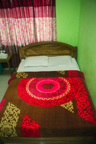 a bed with a red and gold blanket on it at Hotel As Shams International in Dhaka