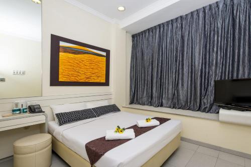 a hotel room with a bed and a television at Hotel 81 Elegance in Singapore