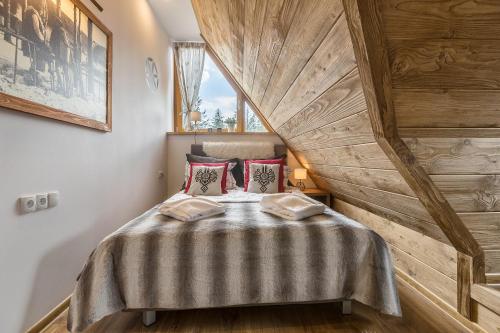um quarto com uma cama e uma parede de madeira em Apartamenty Polana Sywarne Zakopane em Kościelisko