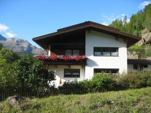 a white house with flowers on the side of it at Ferienwohnung Scheiber in Sölden