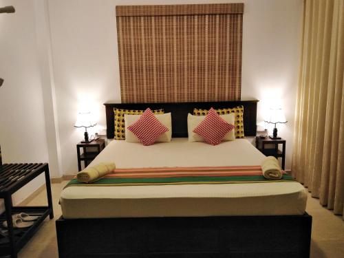 a bedroom with a large bed with pink pillows at Kandy City Village in Kandy