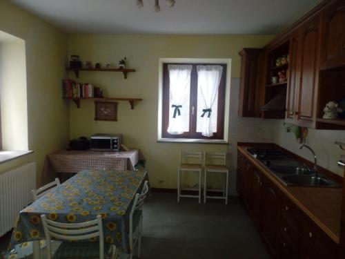a kitchen with a table and a sink and a window at RIVAROLA in Fanano
