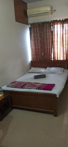 a bed with a wooden frame in a room at Hotel As Shams International in Dhaka