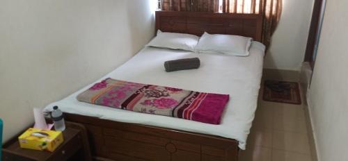 a bed with white sheets and a purse on it at Hotel As Shams International in Dhaka