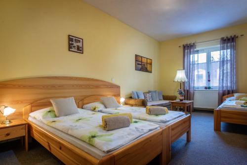 a hotel room with two beds and a couch at Penzión Harmony in Poprad