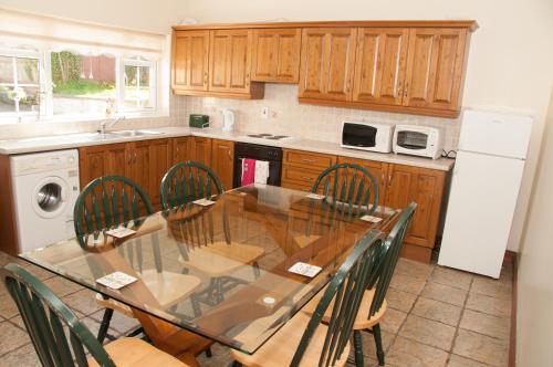 uma cozinha com mesa, cadeiras e geladeira em no 3 Leitrim Road em Carrick on Shannon