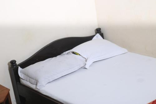 a bed with white sheets and a pillow on it at Hotel As Shams International in Dhaka