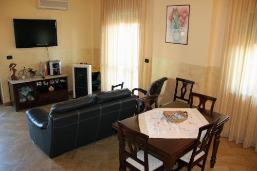 a living room with a black leather couch and a table at Le Villette in Frascineto
