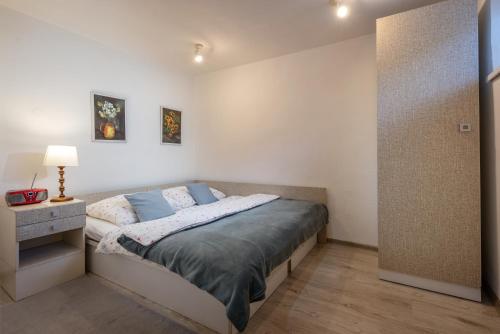 a bedroom with a bed and a night stand with a lamp at Apartment Highway in Poprad