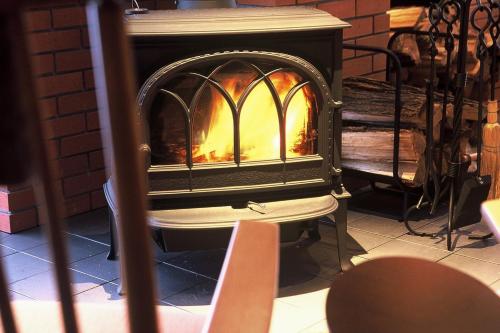 a wood stove with a fire in it at Sanyoan in Otofuke