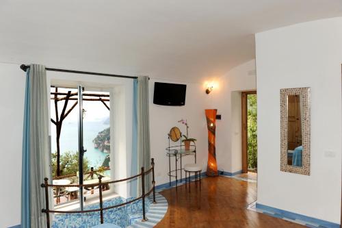 a living room with a sliding glass door leading to a balcony at Fattoria La Tagliata in Positano