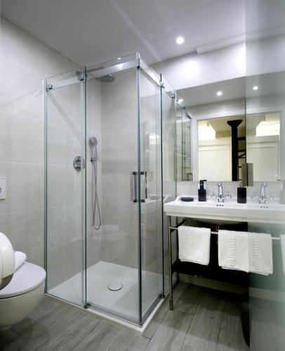 a bathroom with a shower and a toilet and a sink at Pensión Plaza Nueva in Bilbao