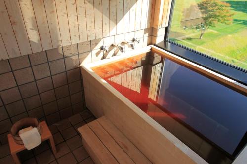 a bathroom with a sink and a window and a tub at Sanyoan in Otofuke