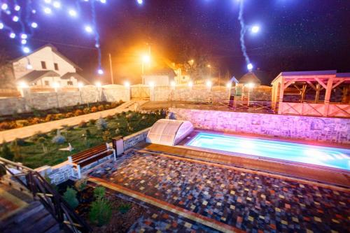a swimming pool at night with lights at GORHouse Hotel in Yaremche