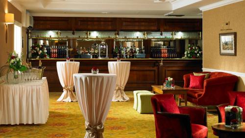 a lobby with a bar with tables and chairs at Hollins Hall Hotel, Golf & Country Club in Bradford