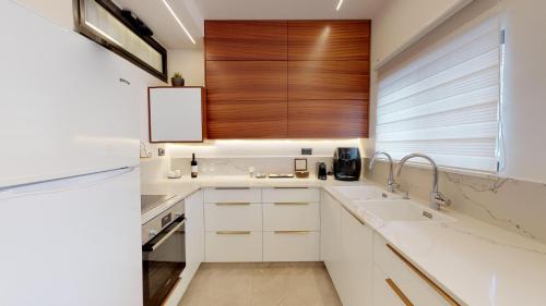 a kitchen with white cabinets and a wooden window at A luxury apartment in the center of Jerusalem in Jerusalem